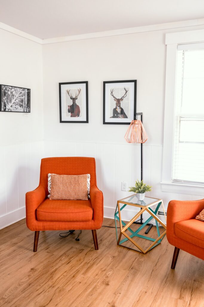 El Paso Airbnb LRT host and co-hosting services for texas landlords. Orange couch with wooden floor on airbnb rental. 